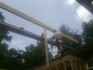 Carpenter setting a ridge beam over a new addition frame — Ice Dam Removal by Roofing Brothers in Leavenworth
