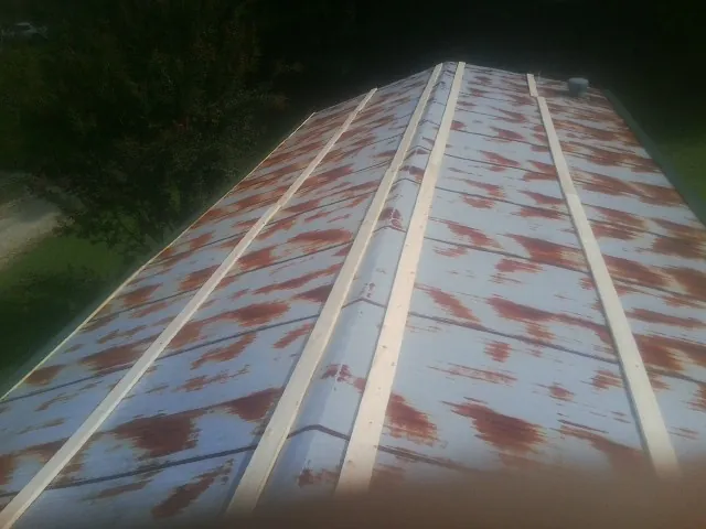 Rusted metal roof panels with new wood purlins before replacement — Storm Damage Roof Repair in Leavenworth by Roofing Brothers